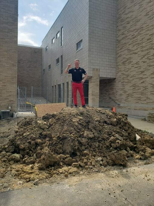 Mr. Marshall standing on a dirt pile