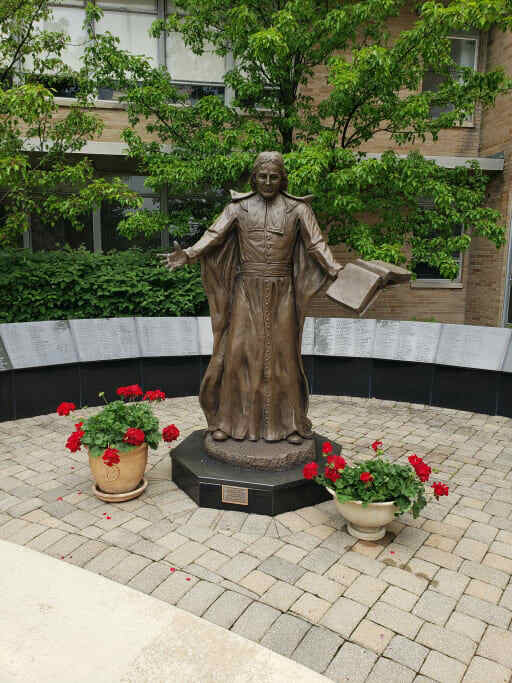 Saint John statue surrounded by flowers